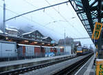 Berner Oberland Bahn, Lauterbrunnen: Am frühen Morgen Einfahrt des Zuges Triebwagen 323 mit Steuerwagen 422 ins stationsseitige Gleis, das normalerweise nicht benutzt wird.