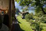 Kurz nach Verlassen des Bahnhofs Brienz gehts in die maximale Steigung von 250 Promille, also gewinnen wir sofort an Hhe. Im  Salon Rouge -Wagen mit Blick zurck auf den Brienzersee, 09. Aug. 2010, 10:53