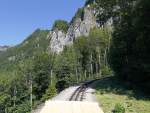 Blick in Fahrtrichtung und Bergmassiv des Brienzer Rothorns, auf Zahnstange mit Steigungen bis 250 Promille (Durchschnitt gesamte Strecke: 225 Promille).