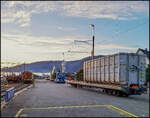 CJ Bf Glovelier__Ebenfalls am frühen Morgen erfolgt das Verladen der Müll-Container von Lkws auf den von CJ speziell entwickelten Wagentyp (Sb), der pro Wagen über eine Ladekapazität von zwei Abfallcontainern mit einem Einheitsgewicht von je 22,5 Tonnen verfügt. 
Der Lastwagen platziert sich in der Längsachse des Bahnwagens, lehnt sich an dessen Abstützung an und lässt den Container in die gewünschte Richtung gleiten. Auf diese Weise wird Müll zur zentralen Müllverbrennung nach La Chaux-de-Fonds transportiert und die Schlacken wieder nach Tavannes zur Weiterverwertung (z.B. Straßenbau).__26-02-2026