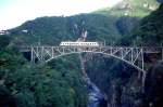 FART Centovalli-Bahn Regionalzug 119 von Domodossola nach Locarno am 16.05.1993 bei Intragna auf Ponte Isorno mit Triebwagen ABe 4/6 55. Hinweis: Brckenhhe 79m, Bogenweite 90m. Zur Verkehrszeit des Zuges ist der Viadukt noch im Schatten, durch den dunklen Hintergrund kommt die Konstruktion gut zur Geltung.
