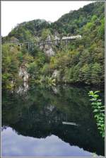 R320 mit ABe 4/6 53 auf dem Ruinacci Viadukt bei Camedo spiegelt sich im Palagnedra Stausee.(03.09.2014)