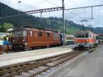 bls + MOB / Im Bahnhof von Zweisimmen wartet die bls E-Lok Re 4/4 166 mti Personenwagen als Regiozug neben dem Ausfahrenden MOB Schnellzug mit GDe 4/4 6005 als Zugslok( ex tpf/GFM GDe 4/4 101 ).. Foto vom 29.07.07