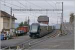Während links im Bild der CEV Gk 37 und ein offener Güterwagen zu sehen sind, verlässt der MOB GoldenPass Express 4065 von Interlaken Ost nach Montreux den schmucken Bahnhof von Chamby,