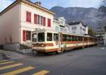 Am Morgen des 29.11.2014 fährt ein Zug der Chemin de fer Aigle-Leysin, bestehend aus Bt351 und BDeh 4/4 302 durch die enge Rue de la Gare in Aigle.