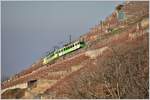 Am gegenüberliegenden Hang steigt ein Zug der ehemaligen Aigle-Leysin Bahn steil die Weinberge hinauf.