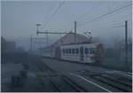 Bei dichtem Nebel und noch in der Morgendämmerung erreicht der TPF Be 4/4 121 mit dem B 207 (ex MOB), B209 (ex MOB) und dem ABt 221 den Bahnhof von Broc Village.