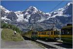 Viel Verkehr auf der Station Wengeneralp, wo sich ein talwärts und zwei bergwärts fahrende WAB Züge kreuzen und dies vor der herrlichen Kulisse der Berge im Hintergrund, wobei in der