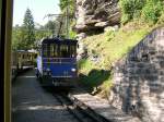 Berner Oberland 2007 - Auch Elektrolokomotiven besitzt die Wengernalpbahn, die hauptschlich im Gterverkehr zwischen Lauterbrunnen und Wengen eingesetzt werden. In der Ausweichstation Rohrfluh begegnet am 26.08.07 ein bergwrts fahrender Gterzug dem talwrts fahrenden Regelzug.