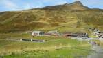 Bahnhof  Kleine Scheidegg , vor dem Gebäude die Jungfraubahn, dahinter die WAB am 4.10.2013   