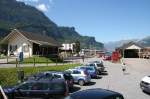 Bahnhof Meiringen 2012. Heute Parkplatz statt Drehscheibe und Abstellgleise. Einziges berbleibsel sind die zwei ausrangierten Gterwagen (Gb-v 2212 + 2213) am Gterschuppen, denen man vorne und hinten das Gleis abgeschnitten hat. (15.08.2012)