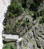 Nahaufnahme eines alten Gebäudes mit ein paar Meter Gleis, aufgenommen von der Staumauer des Lac d'Emosson aus.