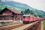 01.08.1991, Schweiz, Abendlicher Besuch auf dem Bahnhof Trun, ein Zug der RhB mit Lok 619 fährt ein.