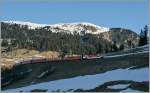 Noch liegt das Tal im Schatten doch die RhB  Glacier Express  Ge 4/4 III leuchtet schon in den kühlen März Morgen.