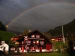 Regenbogen über dem Bahnhofsgebäude Langwies.