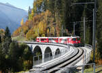 Lok Re 4/4 II 621 mit dem Landwasser-Shuttle von Alvaneu nach Filisur auf dem Schmittnertobel-Viadukt kurz vor der Haltestelle Schmitten GR Landwasserviadukt in der wunderschönen Herbstlandschaft. Filisur, 16.10.2025