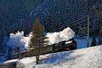 Die Schmalpur Dampflokomotive G 4/5 108 der rhätischen Bahn dampft mit einem Sonderzug von Samedan nach Scuol bei Zernez vorüber.Bild vom 24.1.2015