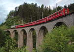 Der erste Zug des Tages, welcher die Albulabahn von Süden her befährt, ist der R 1110 (Samedan - Chur), der Filisur um 05:54 verlassen hat und sich nun auf dem Schmittentobel-Viadukt befindet. Er ist auch die einzige Personenzugleistung auf dieser Strecke, die planmäßig mit einer Ge 4/4 II gefahren wird. Hier ist es die frisch lackierte Ge 4/4 II 611  Landquart , die zwar immernoch für Login wirbt, aber in einem anderen Design.

Schmittentobelviadukt, 13. Juni 2017