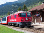 Der Glacier-Express von Zermatt nach St. Moritz durchfährt den Bahnhof Sumvitg-Cumpadials mit dem malerischen Bahnhofsgebäude. Somvix, 31.7.2023