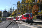 Re 4/4 II 621 fährt mit dem Landwasser-Shuttle in den Bahnhof Filisur ein. An zweitletzter Stelle ist der offene Aussichtswagen ohne Fenster zu sehen. Der Fotograf steht nicht im Gleisbereich. Filisur, 16.10.2025