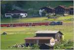 Es riecht nach frischem Heu, wenn RE1229 nach Scuol durch frischgemhte Wiesen fhrt bei Klosters Dorf. (26.06.2010)