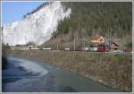 Ge 4/4 II 627  Reichenau-Tamins  zieht einen beachtlichen Gterzug aus 17 Wagen (leer fr Valserwasser) aus der Galerie bei Valendas-Sagogn Richtung Ilanz. (17.04.2007)brigens das weisse Wasser stammt aus dem Bach Ual da Mulin der vom Flimser Skigebiet durch die Bergsturzzone fhrt und sich durch den Kalk weiss verfrbt.