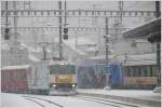 Ge 4/4 III 644  Savognin  und eine Werbe Re 460 begegnen sich am gemeinsamen Bahnsteig in Chur. (28.01.2010)