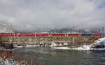 Die Ge 4/4 III 651  Glacier on Tour  fährt mit einem Re über die Rheinbrücke in Reichenau-Tamins.Bild 16.1.2017