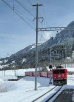 Der Regionalzug Scuol - Chur - Disentis mit der Ge 6/6 II 705 in Castrisch (?) am 22. Mrz 2008