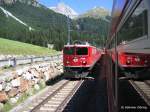 Bei Preda spiegelt sich die entgegenkommende Ge 6/6 II RhB 705 mit ihrem D 1148 im D 1141 Chur - St.