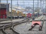 Landquart vor dem RhB Depot. Abgestellter Umbauzug, ein abgestellter Glacier-Express, im Hintergrund Getreidesilowagen beim  Verladen auf die Rollschemel und dazwischen die Ausfahrgeleise in Schlangenlinie Richtung Chur. Die zierlichen RhB-Prellbcke drften vermutlich nur einem kleinen Anprall standhalten. (22.10.2007)