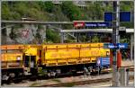 Schilderwald und Fa-u Schotterwagen des Bahndienstes in Reichenau-Tamins. Im Hintergrund überquert soeben ein Postbus nach Flims den Rhein (01.05.2014)