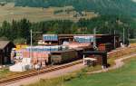 RhB - Abgestellte Güterwagen hinter dem Lager von Josias Gasser in Punt Muragl, August 2000. Werbung für den Josias Gasser Baumaterialien-Express macht dieser Wagen
http://www.bahnbilder.de/bild/schweiz~rhaetische-bahn~guterwagen/87088/rhb---gb-5021-am-08061997.html  und 
http://www.bahnbilder.de/bild/schweiz~rhaetische-bahn~guterwagen/875890/rhb-gb-5021-07032004-landquart.html
 
