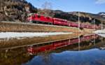 In einem Schneeschmelzwassersee des Winters 2017 spiegelt sich in Waltensburg am 22.Februar ein Re der geführt von der Ge 4/4 II 632  aus Chur kommend nach Disentis unterwegs ist.