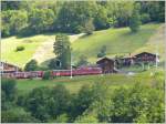 RE1237 mit Ge 4/4 II 613  Domat/Ems  passiert das Stationsgebude von Serneus.