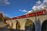 Ge 4/4 II 614  Schiers  fährt mit einem Re nach Scuol über die Chapellabrücke über den Bach Vallember.Bild S-Chanf vom 19.10.2015