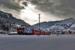 Bei einer sehr kurzen Aufhellung im Oberland fährt die Ge 4/4 II 623 mit einem Re aus Disentis nach Landquart in Castrisch vorüber.Bild vom 20.1.2016