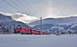 Die Ge 4/4 II 632 fährt mit einem Re aus Disentis nach Chur kurz nachdem die Sonne sich verabschiedet hat in Castrisch vorüber.Bild vom 16.1.2017