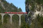 Ge 4/4 III 646. Spektakulr die Aussicht der Reisenden, wenn sie nach einem Tunnel, direkt ber den 65m hohen Landwasserviadukt bei Filisur fahren. Die rote RhB Lok macht brigens Werbung in eigener Sache fr ihr General-Abo und den Ferienpass Graubnden. 13.4.2007