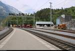 Blick auf den Bahnhof Reichenau-Tamins (CH) der Rhätischen Bahn (RhB) beim Kieswerk Reichenau mit abgestellten Schüttgutwagen.