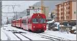 R1816 aus Filisur mit Steuerwagen 1757 trifft bei starkem Regen im verschneiten Davos Platz ein (10.10.2011)