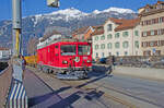 Montag den 05.02.2024 um 10:28 Uhr in Chur (GR). Soeben durchfährt ein Dienstzug?, Bauzug?, Güterzug? oder Rangierfahrt? den RhB Haltepunkt Chur Altstadt. Trotz funktionierender Fahrleitung wird mit Diesel gefahren (Triebfahrzeugführerausbildung?!). Er kommt von Chur her und fährt bis Chur Depot Sand. Dort wird er beiseite gestellt. Links unten im Bild befindet sich das Gewässer der Plessur. Links vom Fahrleitungsmasten im Hintergrund erkennt man die Anschrift der RhB Haltestelle  Chur Altstadt“. Die Strasse auf der die RhB fährt nennt sich hier auf dieser Höhe  Plessurquai“. Die Aufnahme wurde auf der Höhe der  Metzgerbrücke“ gemacht. Der Zug besteht aus folgendem RhB Rollmaterial: -Lokomotive, Gem 4/4 Nr. 802 mit dem an der Seite angebrachten Wappen des Kantons Graubünden sowie einer runden aus Metall gegossenen Scheibe welche ein Murmeltier abzeichnet welches der Lok auch den Namen  Murmeltier“ gibt. Baujahr: 1966, Inbetriebnahme: 1968 (Übergabe nach Anschrift am Fahrzeug war am 09.05.1968). Eine grössere Revision fand im Jahr 2003 statt, eine Metallplakete am Fahrzeug mit der Aufschrift  RhB Hauptwerkstätte Landquart 2003“ weisst darauf hin. Achsfolge: Bo’ Bo’, Dienstgewicht: 50 t, Höchstgeschwindigkeit: 65 km/h. –Wagen, angehängt an diesem Zug sind zwei Altschotterwagen vom Typ Xa-u 8761 und 8762. Die Wagen besitzen einen Stromanschluss für den Entlad. Koordinaten GMS (Grad, Minuten, Sekunden): N 46° 50’ 50.6’’ O 9° 31’ 54.8’’