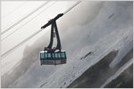 Ein herrlicher Tag beginnt auf dem Brienzer Rothorn. Neben der Dampfzahnradbahn von Brienz gibt es noch die Luftseilbahn von der andern Seite aus Sörenberg. Schon früh verlässt die erste Gondel, noch als Leerfahrt, das Rothorn und verschwindet im Nebelmeer. (20.06.2016)