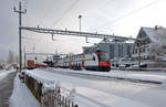 RABe 514 022 wartet im winterlichen Bahnhof Wädenswil auf die Weiterfahrt. Im Überholgleis links wurde ein Containerzug der BLS vorübergehend abgestellt, da die Zustellung nach Domat/Ems aufgrund der dortigen Schneemengen nicht möglich war. 16.01.2021.
