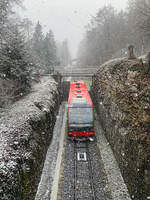 Magglingenbahn fährt bergwärts bei Schneefall.