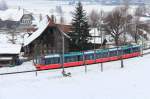 Zwischen Stadt und Land mit der Berner Strassenbahn: Combino-Wagen 752 von Bernmobil vor den imposanten alten Bauernhäusern oberhalb Worb.