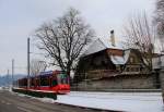 Berner Strassenbahn unter uralten Bäumen ehrwürdiger Landsitze: Bernmobil Combino-Wagen 765 auf der Ueberlandbahn des Regionalverkehrs Bern-Solothurn. Vor den zum Schloss Muri gehörenden Gebäuden, 21.Januar 2016. 