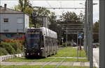 Basler Tram in Frankreich -     Flexity 2 5009 der Linie 3 zum Gare de Saint-Louis auf Rasenbahnkörper entlang der Rue Saint-Exupéry.