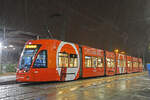 Be 6/8 Flexity 5003 mit der Sunrise Werbung, auf der Linie 3, wartet am 09.12.2022 bei starkem Schneeregen an der Endstation beim Bahnhof Saint Louis.