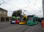 Basel hat doch farbenfrohe Tramzge! Grner Combino 311, Gelbroter Tango 153 und das Werbetram der reformierten Kirche Be 4/6 S 671 am Badischen Bahnhof.